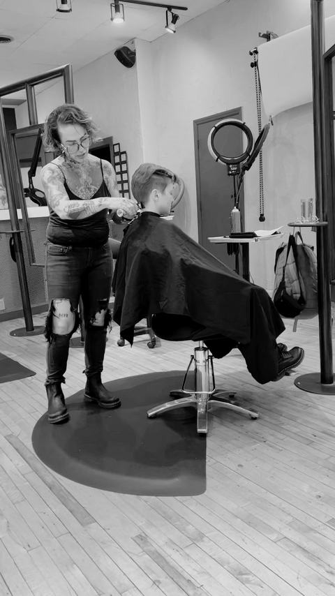 Crain demonstrating a haircutting technique for a class.